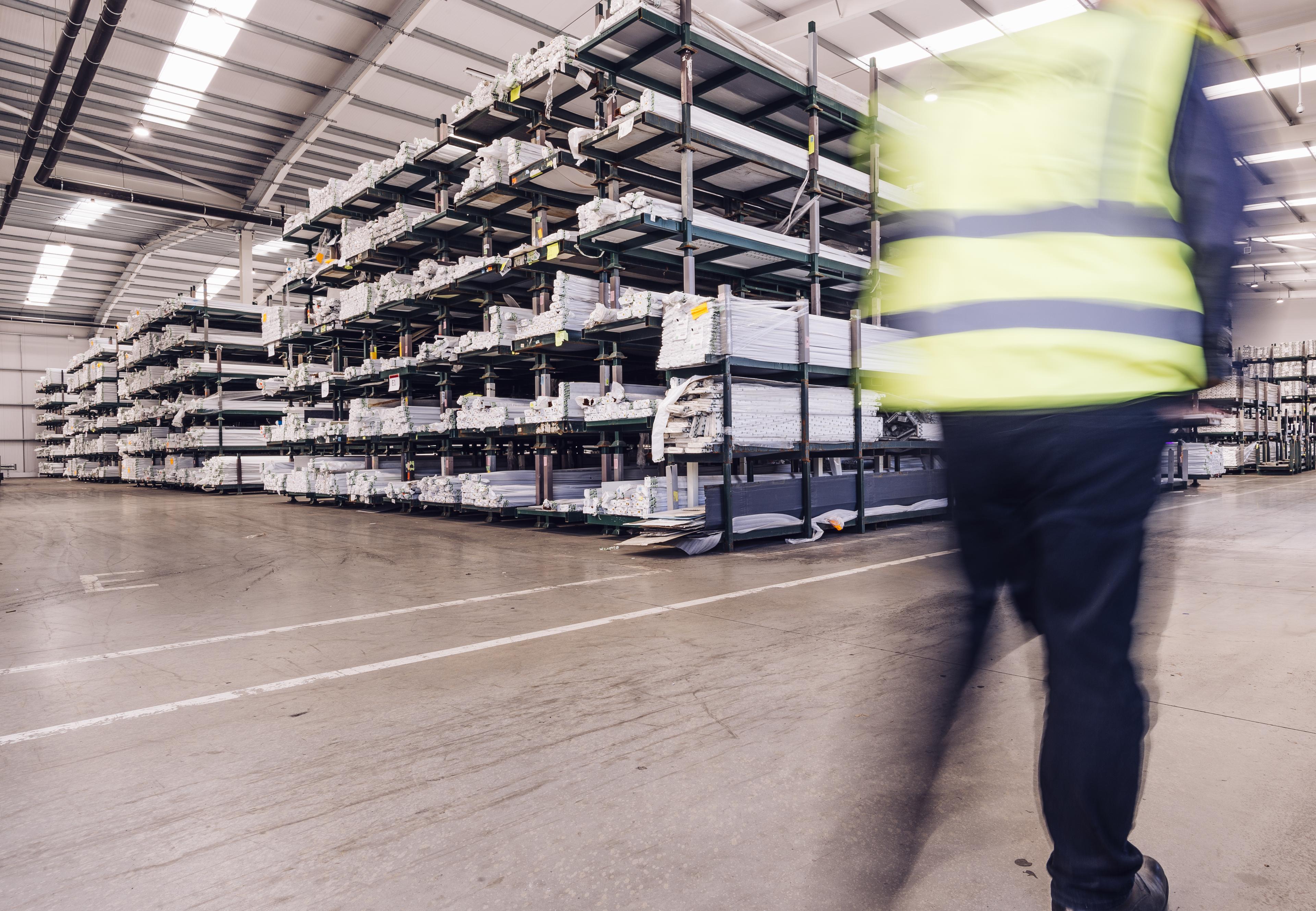 Man wearing high-vis walking through Liniar's warehouse 