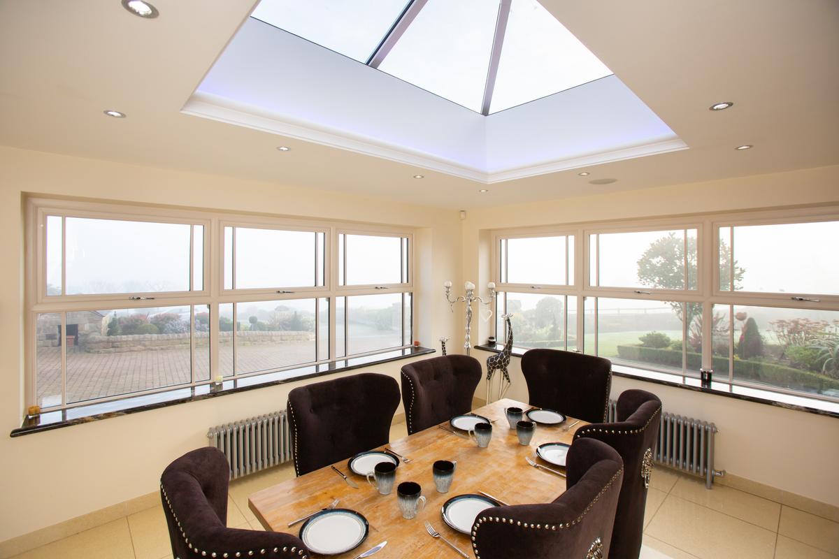 dining room with table and chairs under a white Elevate lantern roof 
